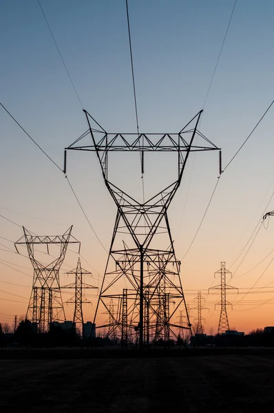 Tours de transmission électrique (pylônes d'électricité) au coucher du soleil — Photo