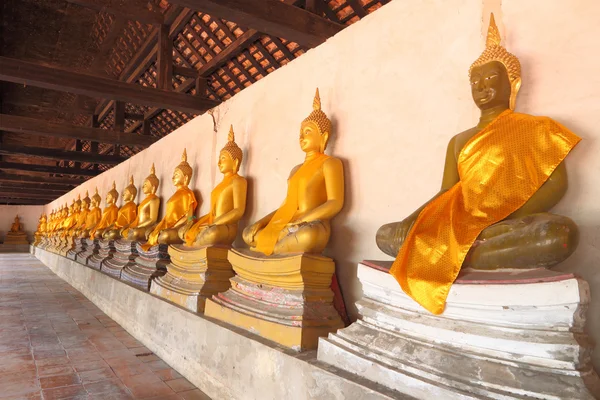 Golden statue of Buddha in shade of church. — Stock Photo, Image