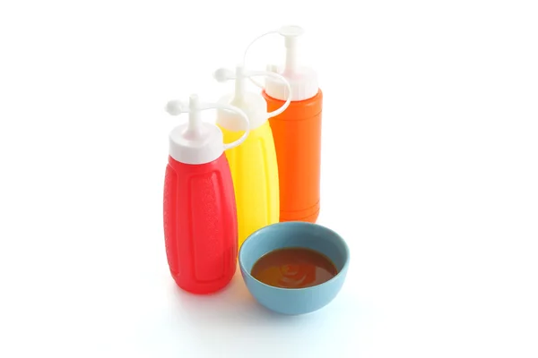 Красный соус чили и трехцветная бутылка на белом столе . — стоковое фото