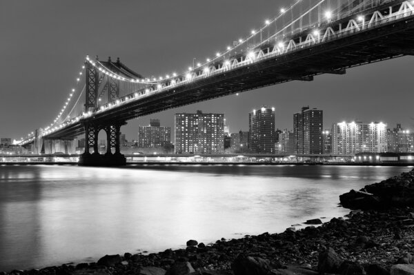 New York City Manhattan Bridge closeup black and white with downtown skyline over East River.