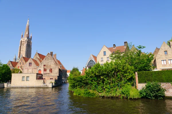 Grachten en de kerk van onze-lieve in Brugge, België — Stockfoto