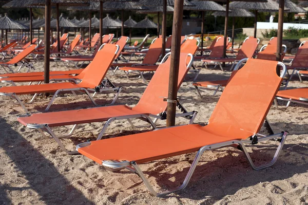Camas de sol e umblellas na praia — Fotografia de Stock