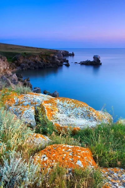 Úžasné skalnaté pobřeží při západu slunce s ostrovem — Stock fotografie