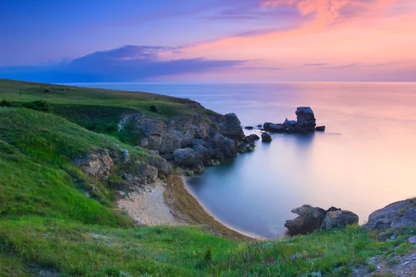Fantastiska klippiga kust vid solnedgången med ön — Stockfoto