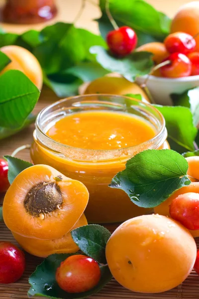 살구와 달콤한 체리 잼 병 및 잎 신선한 과일 — 스톡 사진