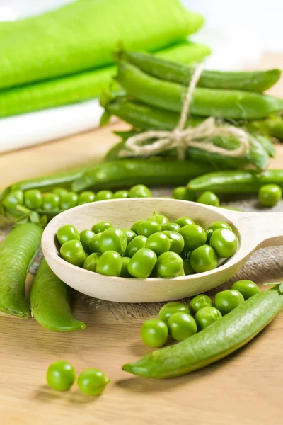 Fresh green peas on the wooden spoon — Stock Photo, Image