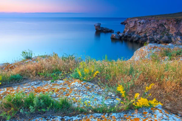 Vackra steniga havskust vid solnedgången — Stockfoto