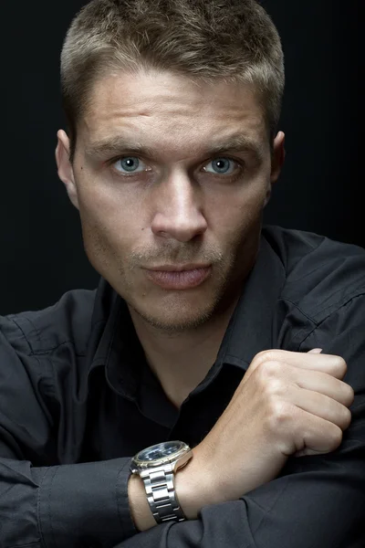 Hombre guapo con reloj en la mano sobre el fondo negro —  Fotos de Stock