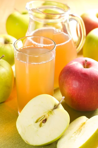 Jablečné šťávy a čerstvé ovoce s listy — Stock fotografie