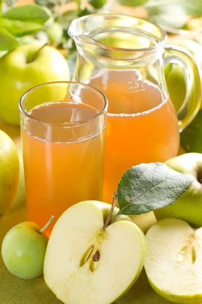 Яблочный сок и свежие фрукты с листьями — стоковое фото