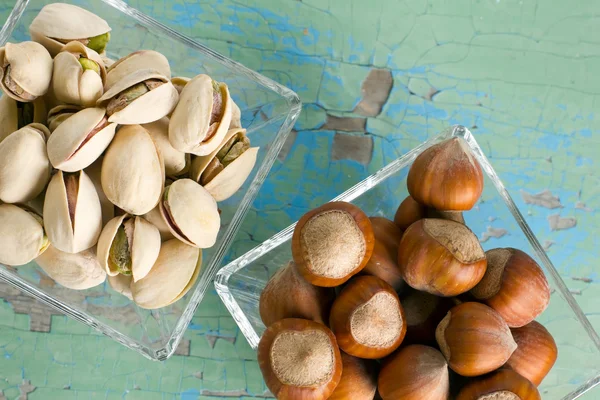 Pistachios and hazelnuts on the vintage wooden surface. — Stock Photo, Image