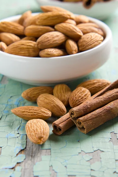 Aroma spices. Cinnamon and almonds on the vintage wooden surface. — Stock Photo, Image