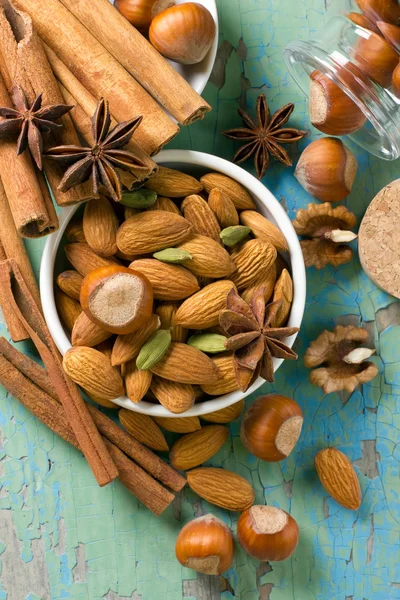 Vůně koření rám. skořice, anýz, arašídy, mandle, kardamon, lískové ořechy na vinobraní dřevěného povrchu. — Stock fotografie