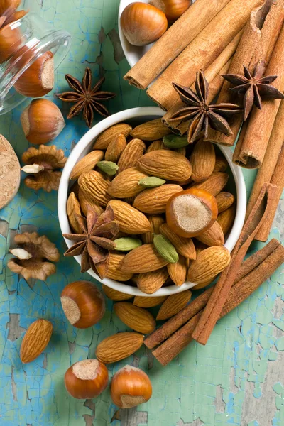 Vůně koření rám. skořice, anýz, arašídy, mandle, kardamon, lískové ořechy na vinobraní dřevěného povrchu. — Stock fotografie