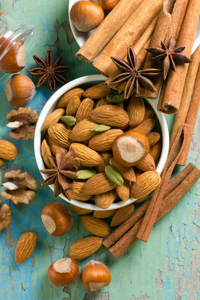 Aroma spezie cornice. Cannella, anice, arachidi, mandorle, cardamomo, nocciole sulla superficie di legno vintage . — Foto Stock