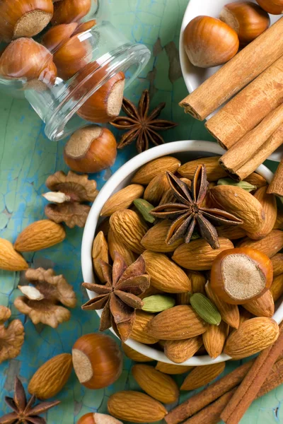 Aroma kryddor ram. kanel, anis, jordnötter, mandel, kardemumma, hasselnötter på vintage trä ytan. — Stockfoto
