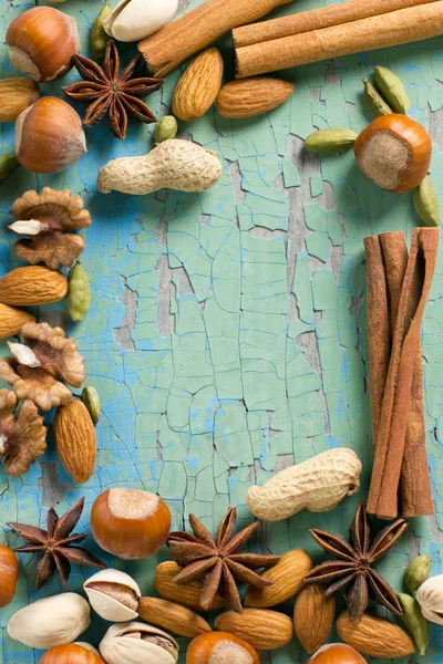 Άρωμα μπαχαρικά πλαίσιο. κανέλα, γλυκάνισο, φιστίκια, αμύγδαλα, κάρδαμο, φουντούκια στην εκλεκτής ποιότητας ξύλινη επιφάνεια. — Φωτογραφία Αρχείου