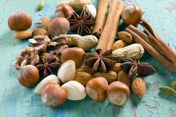 Aroma Gewürze. Zimt, Anis, Erdnüsse, Mandeln, Kardamom, Haselnüsse auf der Holzoberfläche. — Stockfoto