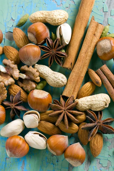 Aroma specerijen. kaneel, anijs, pinda's, amandelen, kardemom, hazelnoten op het vintage houten oppervlak. — Stockfoto