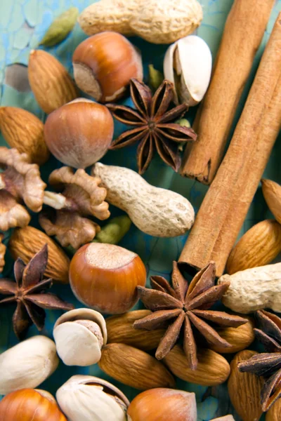Spezie aromatiche. Cannella, anice, arachidi, mandorle, cardamomo, nocciole sulla superficie di legno vintage . — Foto Stock