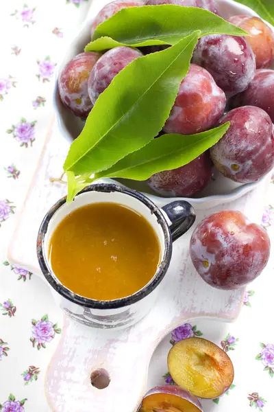 Jus de prunes et fruits frais aux feuilles — Photo