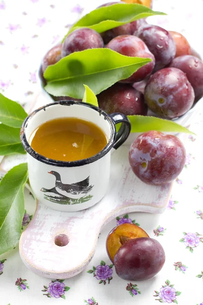 Śliwki soki i świeże owoce z liści — Zdjęcie stockowe