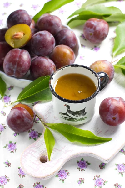 Succo di prugna e frutta fresca con foglie — Foto Stock