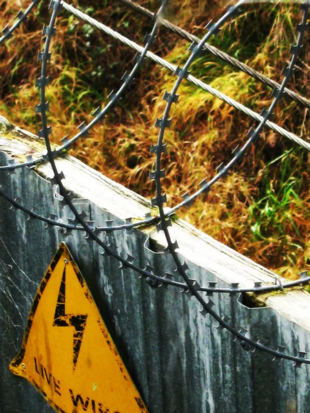 Podepsat na ostnatý drát bezpečnostní plot — Stock fotografie