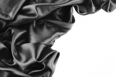 Closeup of folds in black silk fabric on white background clipart