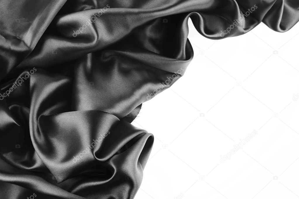Closeup of folds in black silk fabric on white background