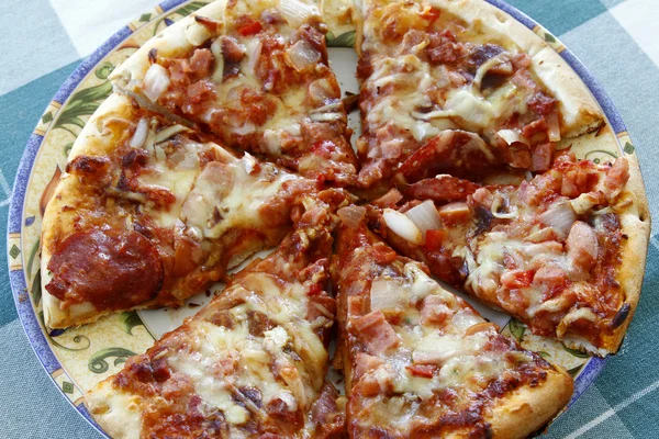 Plasterki pizzy na talerz, na Obrus — Zdjęcie stockowe