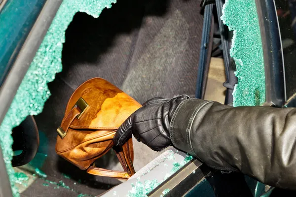 Un voleur a volé un sac dans une voiture. — Photo