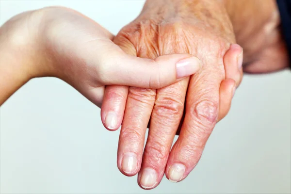 Velho e jovem mão com bengala — Fotografia de Stock