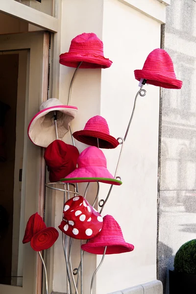 Red hats in front of a millinery — Stock Photo, Image