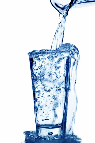 A água é enchida em um copo de água — Fotografia de Stock