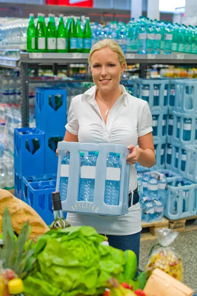 Vrouw kopen gebotteld water in de supermarkten — Stockfoto