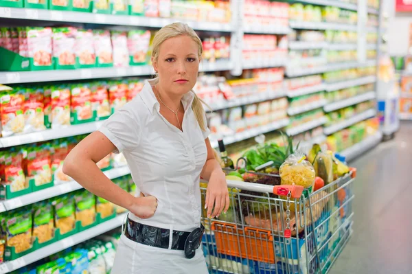 Mulher com carrinho de compras no supermercado — Fotografia de Stock