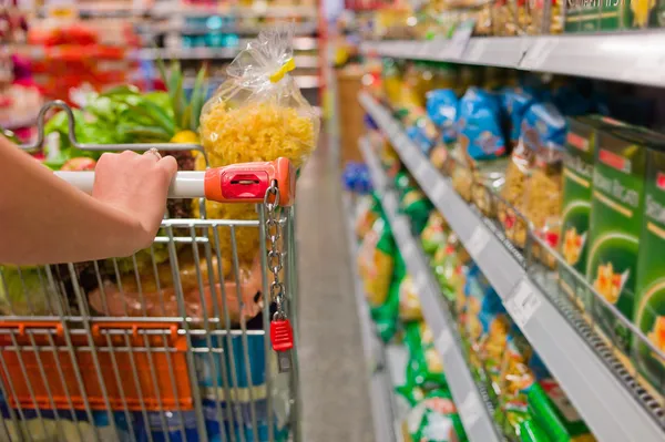 Mujer con carrito de compras en el supermercado — Foto de Stock
