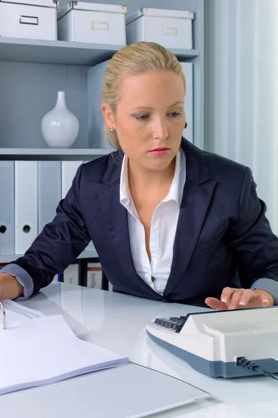 Woman in office with a calculator — Stock Photo, Image