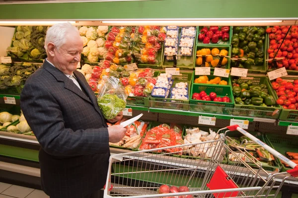 Senior kauft Lebensmittel im Supermarkt ein — Stockfoto