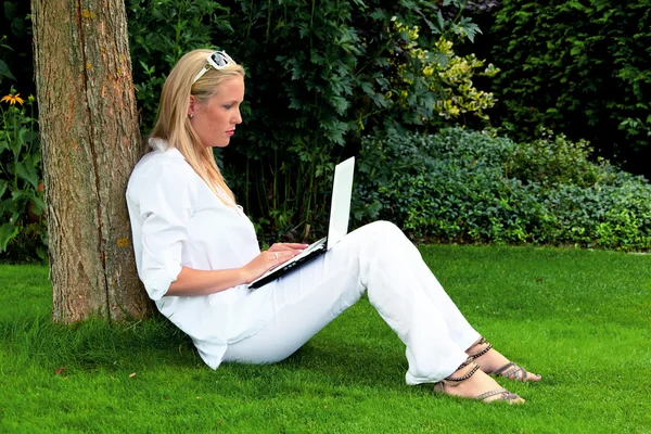 Nő a kertben, laptop számítógéppel — Stock Fotó