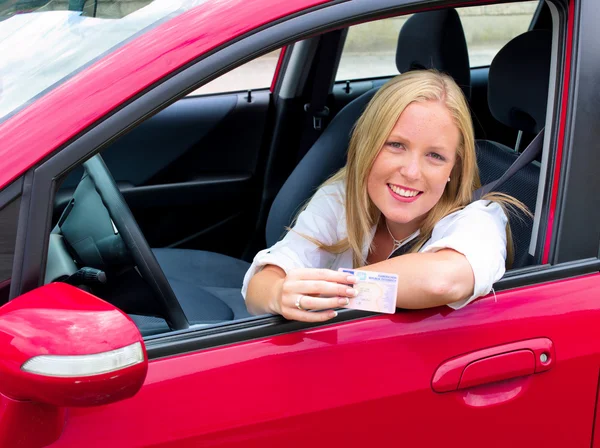 Mladá žena držící řidičský průkaz — Stock fotografie