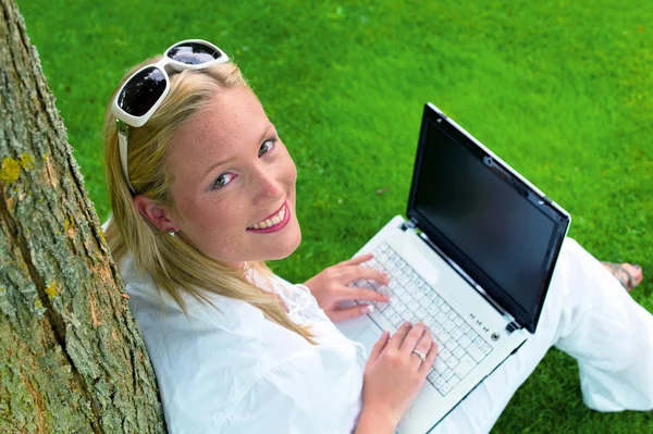 Žena s přenosný počítač v zahradě — Stock fotografie