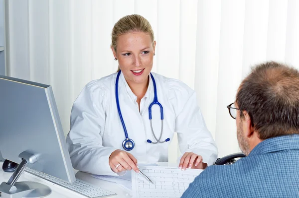 Doctor with stethoscope talking to patients — Stock Photo, Image