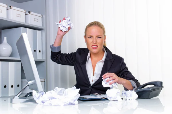 Женщина в офисе с мятой бумагой — стоковое фото