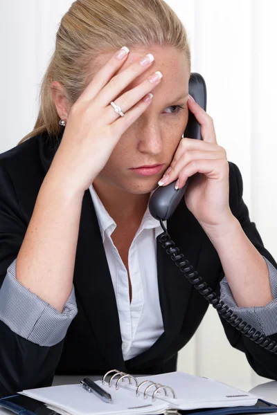 Απογοητευμένοι γυναίκα που κρατά το τηλέφωνο στο γραφείο — Φωτογραφία Αρχείου