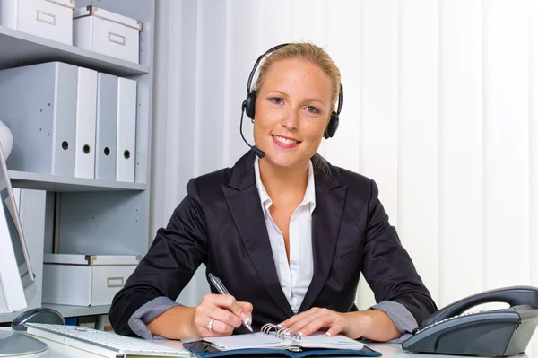 Friendly woman with a headset in customer service — Stock Photo, Image
