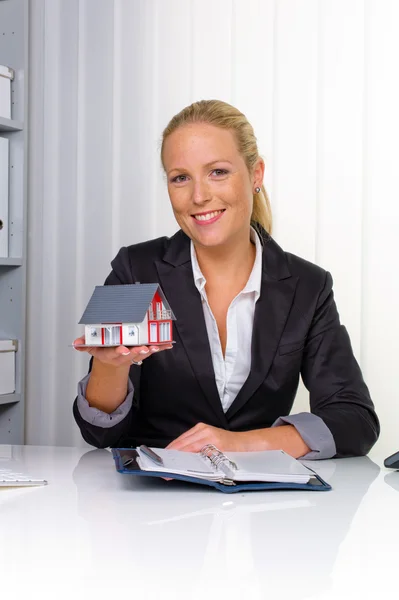 Real estate agent in haar kantoor — Stockfoto