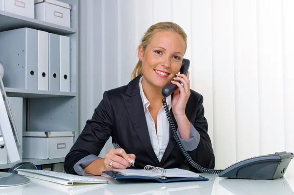 Женщина с телефоном в офисе — стоковое фото