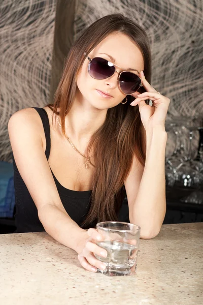 Mooie brunette met een glas wodka — Stockfoto